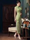 Side profile view of a woman in a green cheongsam dress, highlighting the handcrafted knot buttons along the placket, the magnolia floral print, and the smooth mulberry silk fabric texture.