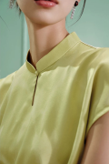 Detailed close-up of the water drop collar and traditional frog button on a green chinese cheongsam shirt, made of premium mulberry silk with subtle jacquard texture.