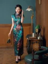 Women's vintage green printed silk long qipao side view, model standing by antique desk in retro room, elegant cheongsam