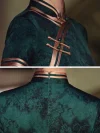 Close-up details of dark green vintage floral qipao, featuring jade-like frog buttons, satin-trimmed collar, and hidden back zipper.