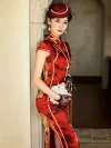 Side view of a woman in a high-end mulberry silk cheongsam dress with red and yellow floral print, leaning against a stone column. The high slit design and pearl clutch add vintage glamour to this Old Shanghai style qipao.