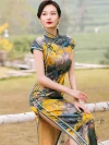Close-up of a model in a women high end yellow mulberry silk cheongsam dress, showcasing the traditional frog buttons, mandarin collar, and intricate landscape print details.