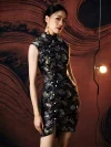 Model wearing ink black modern Chinese silk mini cheongsam dress, showcasing the high mandarin collar, pearl frog buttons, and all-over colorful koi fish brocade pattern on premium satin fabric in a warm studio setting.