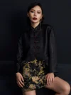 Mid-shot of the ink black tiger jacquard high waist A-line short skirt paired with a black cropped Chinese jacket, showcasing the detailed tiger jacquard pattern and the skirt's flattering A-line fit; bold black mini skirt with traditional-inspired design
