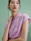 Close-up of a woman wearing a lavender women's modern Chinese mulberry silk cheongsam shirt, highlighting the smooth silk texture and sophisticated stand collar of this refined qipao top.