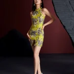 Front view of a woman wearing the modernized lemon yellow short qipao dress with grey floral jacquard pattern, featuring halter neck, keyhole detail, and side slit; form-fitting women's qipao dress for contemporary fashion