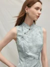 Close-up of the mandarin collar and handcrafted buttons on a light blue modern Chinese sleeveless cheongsam dress, showcasing the intricate floral jacquard texture.