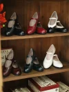 Full color collection of Margarita 1920s Vintage Schoolgirl Style Leather Qipao Mary Jane Shoes, including black, red, white, brown, and green, displayed on a vintage wooden shelf.