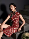 Woman model seated on stairs, showcasing the tailored fit and intricate crane print pattern of a rich red modern cotton cheongsam dress, blending traditional cheongsam elements with contemporary style.