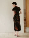 Back view of a modern Chinese qipao dress, showing the sleek silhouette and subtle side slit design. The black mulberry silk cheongsam features a delicate nature print, highlighting traditional craftsmanship.