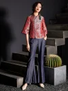 Full-body standing shot of a woman in the modern Chinese red jacquard satin cheongsam top, paired with wide-leg jeans; showcasing the elegant fit and intricate pattern of this women's qipao top