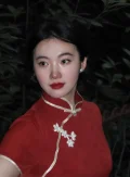 Close-up night shot of the traditional white floral frog button and high collar on a modern red qipao, highlighting the intricate craftsmanship of this midi-length red qipao dress.