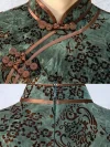 Close-up of custom Momo qipao details, showing the traditional frog buttons, satin trim, and vintage velvet print fabric texture.
