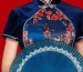 Close-up of navy velvet floral mandarin collar cheongsam blouse, elegant chinese qipao style top with a folding fan on classic red background