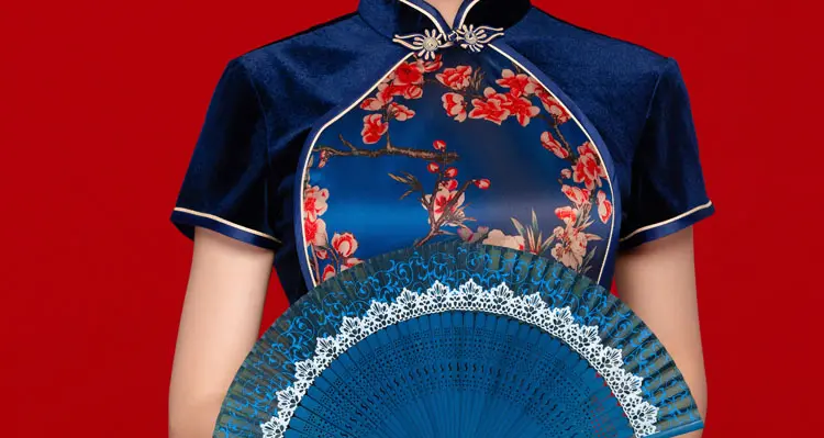 Close-up of navy velvet floral mandarin collar cheongsam blouse, elegant chinese qipao style top with a folding fan on classic red background