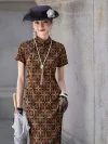 Close-up view of a women's Old Shanghai checkered cheongsam, featuring a geometric checkered print in warm earthy tones. The model wears the long qipao dress with a traditional frog button stand-up collar, styled with a long pearl necklace, lace gloves, and a vintage net hat, highlighting the fabric texture and classic details.