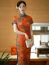 Vintage Old Shanghai style long cheongsam (qipao) in tangerine red with peony floral print and blue trim, elegant women's traditional Chinese dress, model holding a book.
