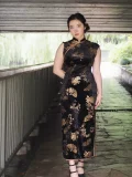 Full-body styled look of the black chinese cheongsam dress, a Chinese Black Sleeveless Plus Size Long Daily Cheongsam with classic gold bamboo and fan motifs. This qipao black dress is paired with modern accessories, showcasing its versatility as a daily wear piece for plus size women.