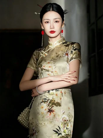 Woman in a 19 momme mulberry silk printed midi cheongsam dress, standing with arms crossed and holding a pearl handbag in a dim vintage interior.