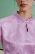 Detailed view of the water drop collar and keyhole neckline on a purple women's qipao top, a modern chinese cheongsam shirt crafted from luxurious mulberry silk.