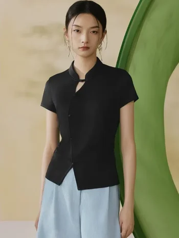 Full front view of a black modern qipao top, a versatile qipao inspired top with mandarin collar and traditional frog buttons, worn by a model in a minimalist studio.