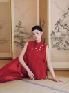 2 Piece Red Chinese Cheongsam Dress - Woman in modern two-piece cheongsam reclining on the floor in a traditional Chinese room, showcasing the elegant silhouette of the textured red mandarin collar vest and matching skirt, red cheongsam for wedding photoshoots.