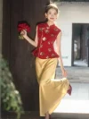 2 Piece Red and Gold Qipao - Modern bridal qipao with gold floral sequins on red sleeveless top, paired with golden satin maxi skirt, bride holding red bouquet in sunlit outdoor traditional Chinese setting
