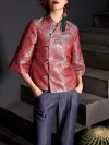 Mid-shot of a woman wearing the red jacquard satin qipao top with hands in jeans pockets, showcasing the blue frog buttons and wave pattern of this modern Chinese cheongsam top