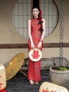 Red Chinese Cheongsam Dress, woman in red lace cheongsam holding double happiness fan, standing in traditional Chinese setting with oil paper umbrella, sleeveless lace qipao for wedding photoshoot