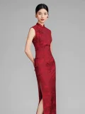 Side-back view of woman in red floral qipao dress, showcasing the form-fitting silhouette, high side slit, and traditional frog buttons on this sleeveless vintage chinese cheongsam.