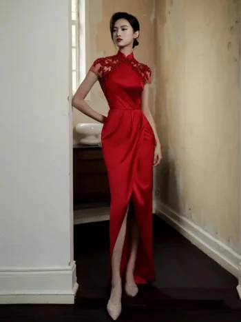 Model in a red floral embroidery satin wedding qipao dress, elegant lace qipao red with sheer embroidered short sleeves, high slit, and mandarin collar, posing in a vintage-style corridor.