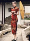Side view of a woman in a red floral vintage silk qipao dress with delicate lace trim on the high side slit, holding a yellow parasol to show the cheongsam’s elegant movement.