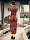 Back view of a woman in a red floral vintage silk qipao dress walking in a Chinese garden, showcasing the rear fit, hidden back zipper, and intricate peony print details.