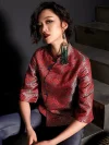 Close-up shot of a woman wearing the modern Chinese red jacquard satin cheongsam top, featuring intricate wave pattern, blue frog buttons, and high collar; paired with jeans for contemporary qipao top fashion