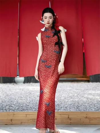Red Lace Chinese Slim Fit Cheongsam Dress, full body shot of woman in form-fitting red lace cheongsam with blue frog buttons standing in front of red curtains, elegant sleeveless qipao for traditional events