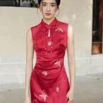 Upper body close-up of women's red modern wedding cheongsam dress, sleeveless Chinese qipao with teardrop mandarin collar, tassel accents, and intricate golden floral & butterfly embroidery