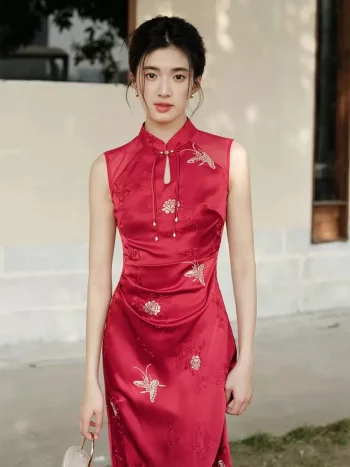 Upper body close-up of women's red modern wedding cheongsam dress, sleeveless Chinese qipao with teardrop mandarin collar, tassel accents, and intricate golden floral & butterfly embroidery