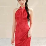Front view of women's red mulberry silk halter neck midi qipao dress, a wedding cheongsam with pearl-trimmed mandarin collar, subtle floral jacquard, and slim fit silhouette for bridal occasions