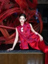 Red Silk Modern Qipao Set - Woman reclining on a black marble countertop in a red brocade qipao vest with floral frog buttons, paired with matching satin bottom, showcasing intricate details of the elegant qipao set