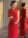 Modern Qipao Wedding Dress - Bride modeling a red sleeveless long qipao in a trial room, with mirror reflection showing both front and back views. The modified qipao features floral embroidery at the collar, traditional frog buttons along the side, and a sleek silhouette, ideal for bridal prep and wedding day styling.