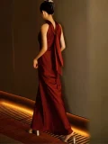 Side back view of a red sleeveless qipao long dress, a luxurious satin Chinese wedding qipao dress with a flowing silhouette, ideal for modern bridal looks.