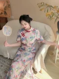 Seated shot of a plus size woman in a retro floral short sleeve cheongsam dress, holding a hand fan in a cozy living room, showcasing the elegant drape and vibrant pattern of this classic cheongsam.