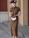 Full-length view of a women's Shanghai checkered long cheongsam, a vintage Old Shanghai qipao dress with a geometric checkered print. The model stands outdoors near a historic building, holding a white pearl handbag, wearing the classic qipao with short sleeves, high slit, and stand-up collar, styled with a net hat and pearl necklace.
