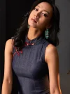 Close-up view of a woman wearing a short sleeveless qipao dress, highlighting the mandarin collar and traditional frog buttons of this classic women's qipao.
