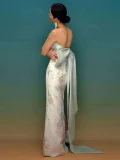 Back view of modern qipao prom dress in mint green and white jacquard, featuring a large satin bow at the back and mermaid silhouette with side slit.