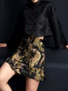 Side view shot of the ink black tiger jacquard high waist A-line short skirt, highlighting the A-line silhouette, detailed tiger jacquard pattern, and functional pockets; structured black mini skirt for edgy modern style
