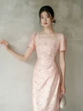 Upper body close-up of women's summer modified cheongsam, new Chinese waist cinched pleated dress in light pink textured fabric, highlighting square neck puff short sleeve and tailored fit for summer