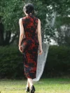 Back view of women's vintage floral sleeveless high cut long qipao (cheongsam) with red dragon print on black fabric, model walking outdoors, showing the back design and high slit detail.