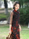 Women's vintage floral high cut qipao (cheongsam) with vivid red dragon print on black fabric, styled with a sheer heart-patterned mesh shawl, model walking outdoors holding a small handbag.