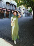 White 1920s Qipao dress goat leather shoes with delicate cutout details, paired with a green vintage cheongsam, worn by a model standing on old Shanghai cobblestone street.